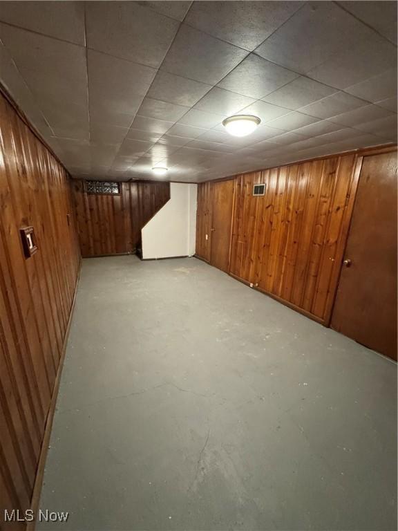 basement featuring wood walls