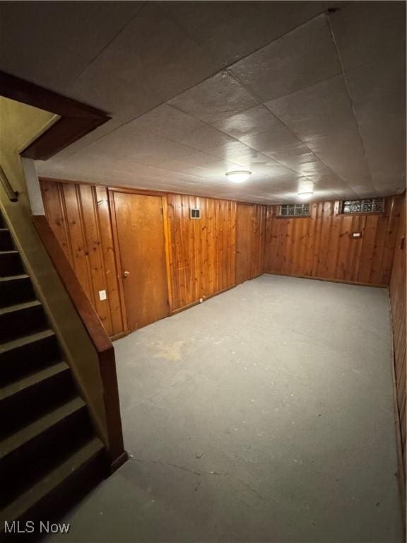 basement featuring wood walls