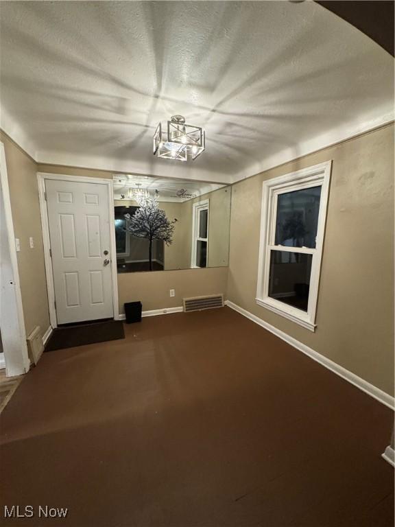 carpeted spare room with a textured ceiling