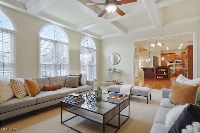 living room with beamed ceiling, coffered ceiling, ceiling fan with notable chandelier, and light hardwood / wood-style flooring