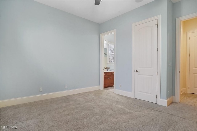 unfurnished bedroom with light carpet, connected bathroom, and ceiling fan