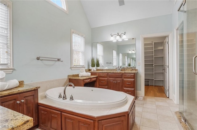 bathroom with vanity, lofted ceiling, tile patterned floors, and plus walk in shower