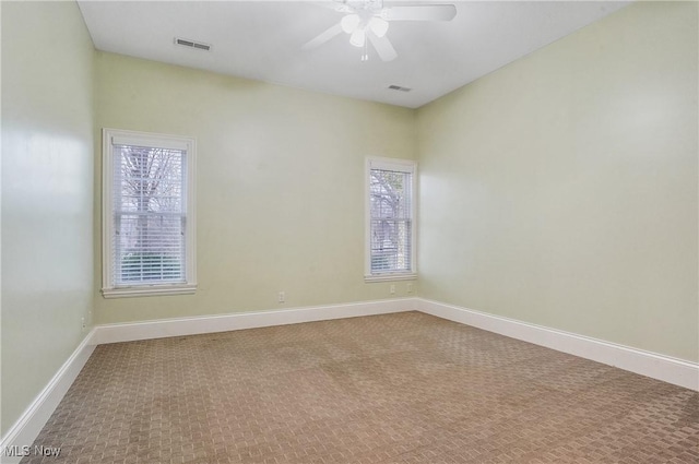 carpeted spare room with a healthy amount of sunlight and ceiling fan