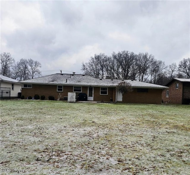 rear view of property with a yard