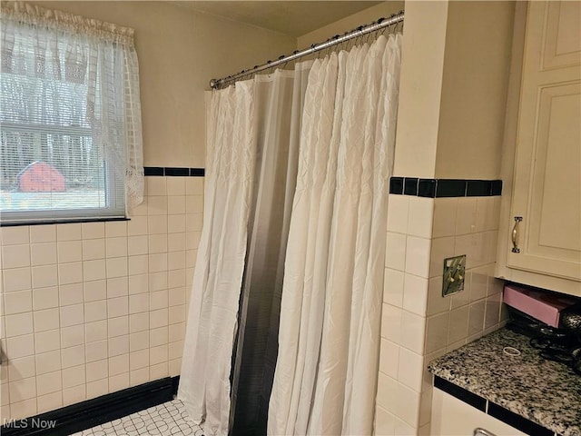 bathroom featuring tile patterned flooring and tile walls