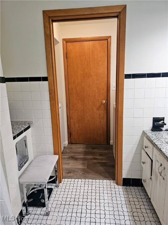 bathroom with vanity, hardwood / wood-style floors, and tile walls