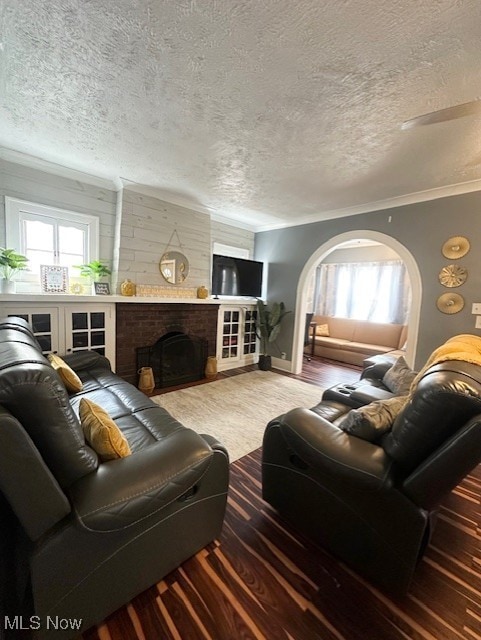 living room with ornamental molding, a healthy amount of sunlight, a textured ceiling, and a fireplace