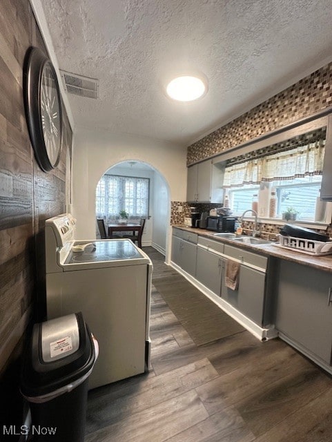 kitchen featuring tasteful backsplash, dark wood-type flooring, sink, and a textured ceiling