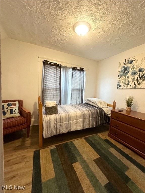 bedroom with wood-type flooring and a textured ceiling