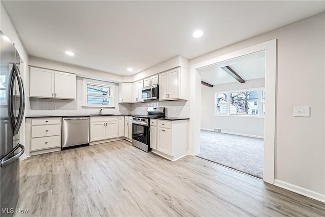 kitchen featuring white cabinetry, appliances with stainless steel finishes, and plenty of natural light