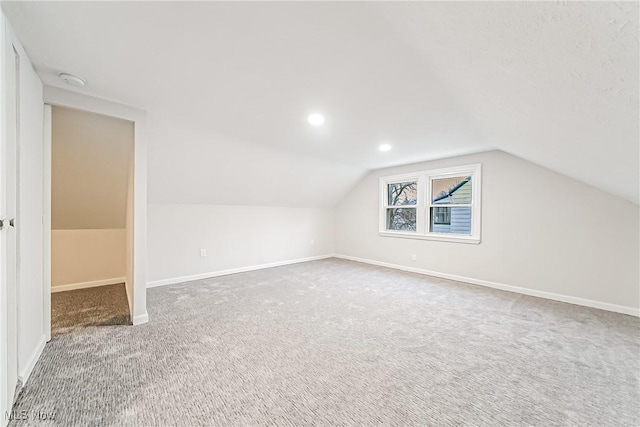 bonus room featuring lofted ceiling and carpet flooring