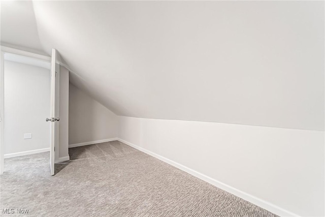 additional living space with lofted ceiling and carpet flooring