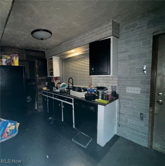 kitchen with sink, dishwasher, and brick wall