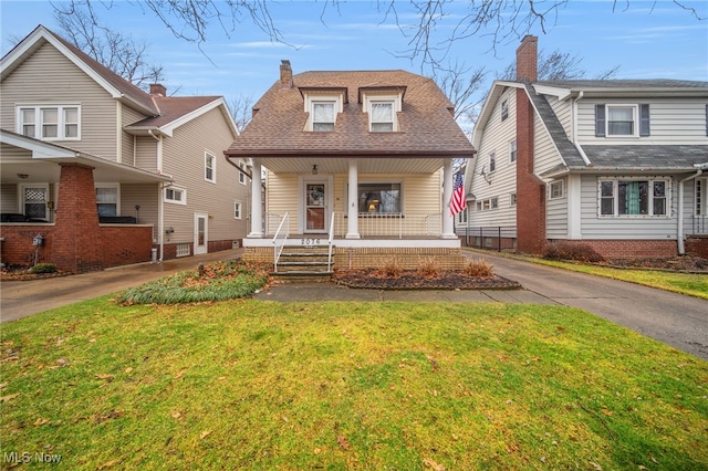 bungalow with covered porch and a front lawn