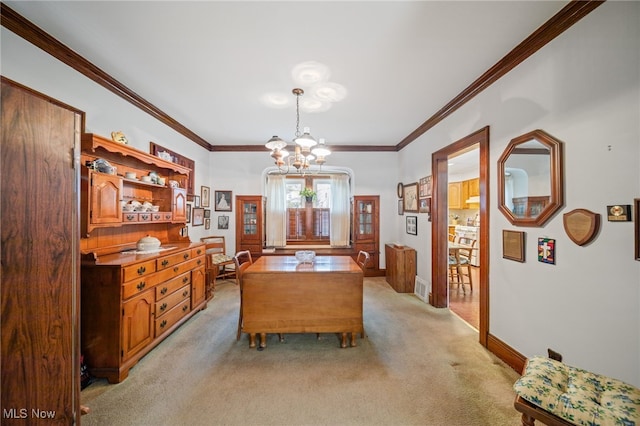 dining space with a notable chandelier, ornamental molding, and light colored carpet