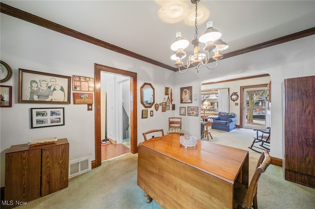 carpeted dining room featuring crown molding and a notable chandelier