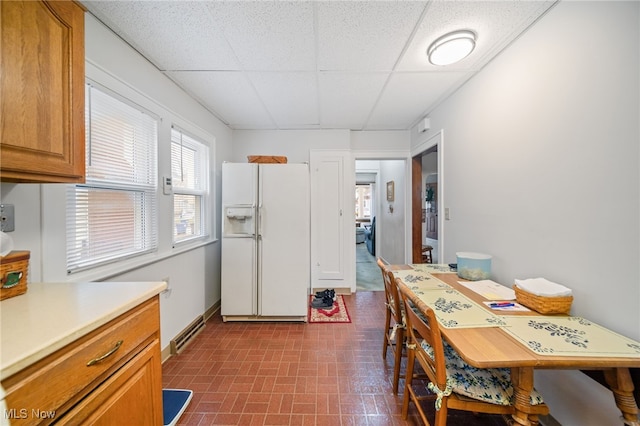 dining room featuring a drop ceiling and a baseboard radiator