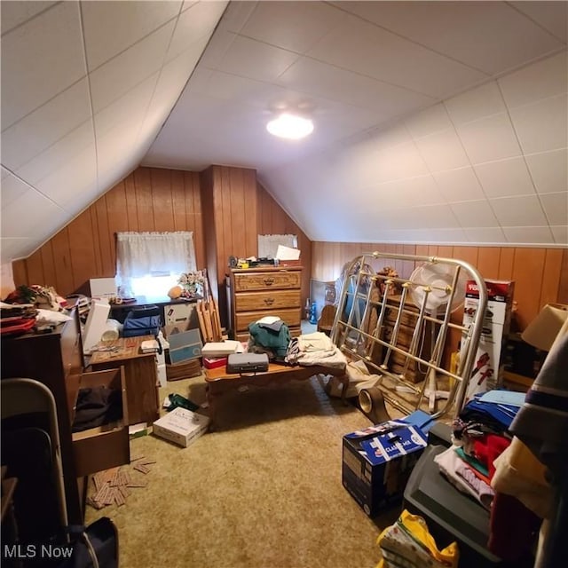 additional living space featuring lofted ceiling, wood walls, and carpet flooring