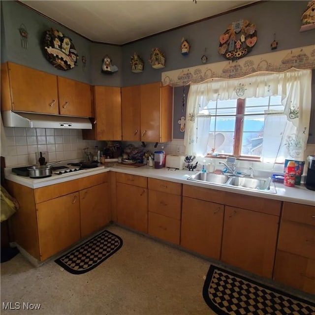 kitchen featuring sink, backsplash, and white cooktop