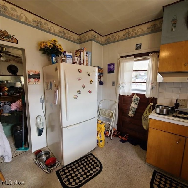 kitchen featuring backsplash and white fridge