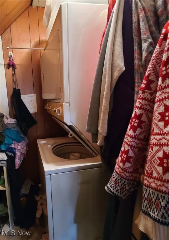 clothes washing area with stacked washer / dryer