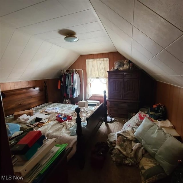 bedroom with wooden walls and vaulted ceiling