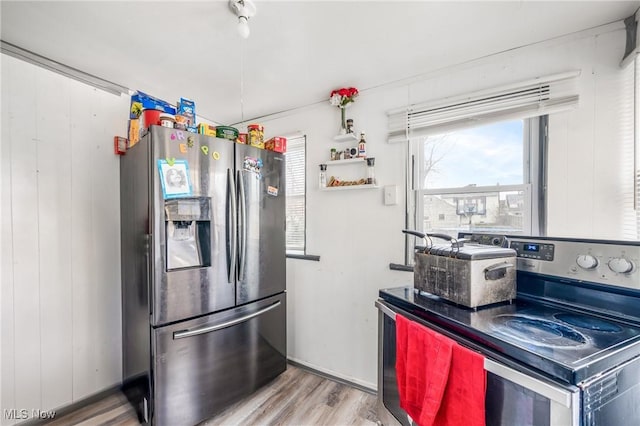 kitchen with appliances with stainless steel finishes and light hardwood / wood-style floors