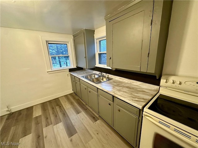 kitchen featuring gray cabinets, sink, white range with electric stovetop, and light hardwood / wood-style flooring