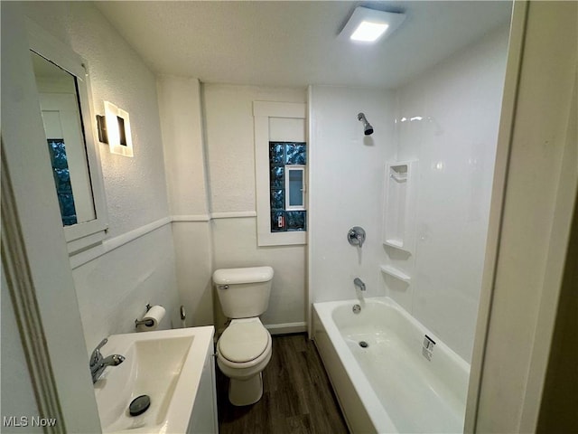 full bathroom with sink,  shower combination, hardwood / wood-style floors, and toilet