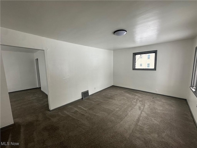 empty room featuring dark carpet