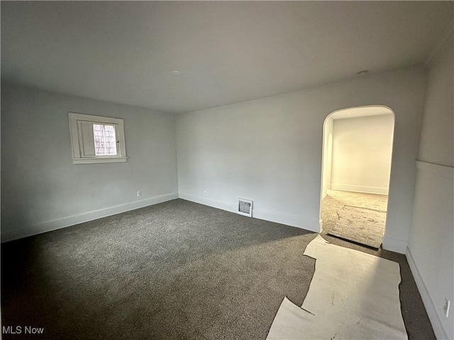 spare room with dark colored carpet