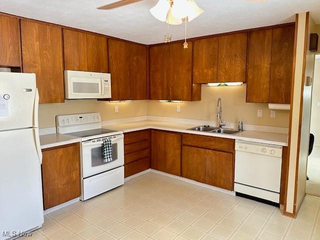 kitchen featuring ceiling fan, sink, and white appliances