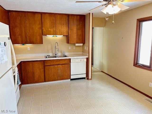 kitchen with sink, white appliances, a healthy amount of sunlight, and ceiling fan