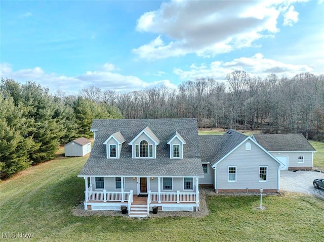 cape cod-style house featuring a porch, a front yard, and a storage unit