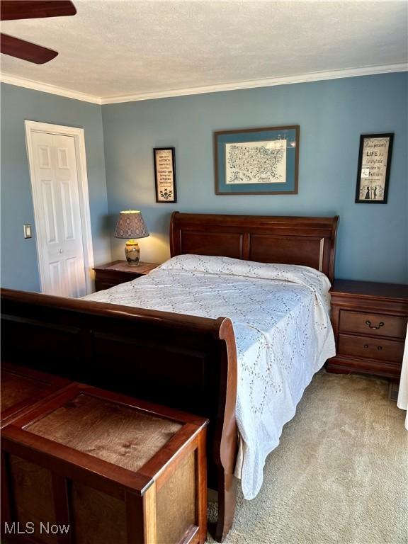 130 Rauch Dr, Marietta, OH 45750 - carpeted bedroom featuring crown molding, ceiling fan, a closet, and a textured ceiling