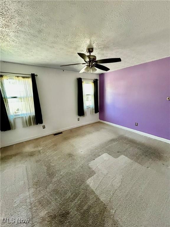 130 Rauch Dr, Marietta, OH 45750 - spare room featuring ceiling fan, plenty of natural light, carpet flooring, and a textured ceiling