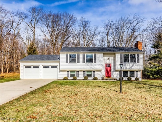 raised ranch featuring a garage and a front lawn