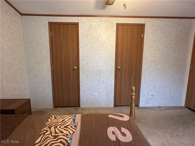 unfurnished bedroom featuring crown molding and carpet