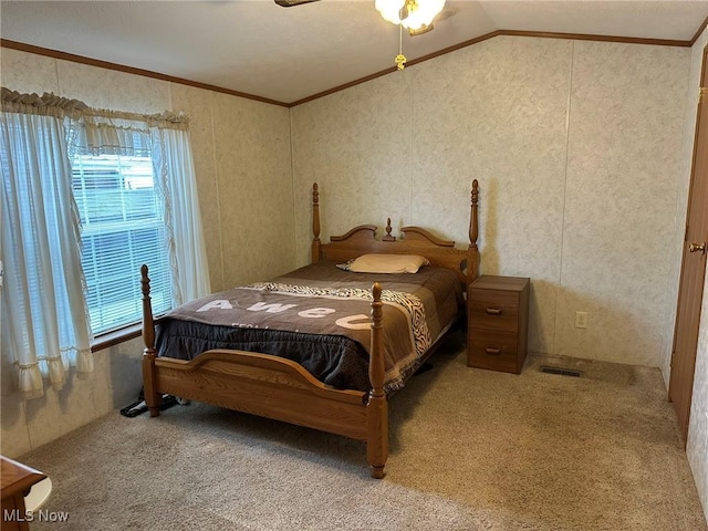 carpeted bedroom with crown molding, lofted ceiling, and ceiling fan