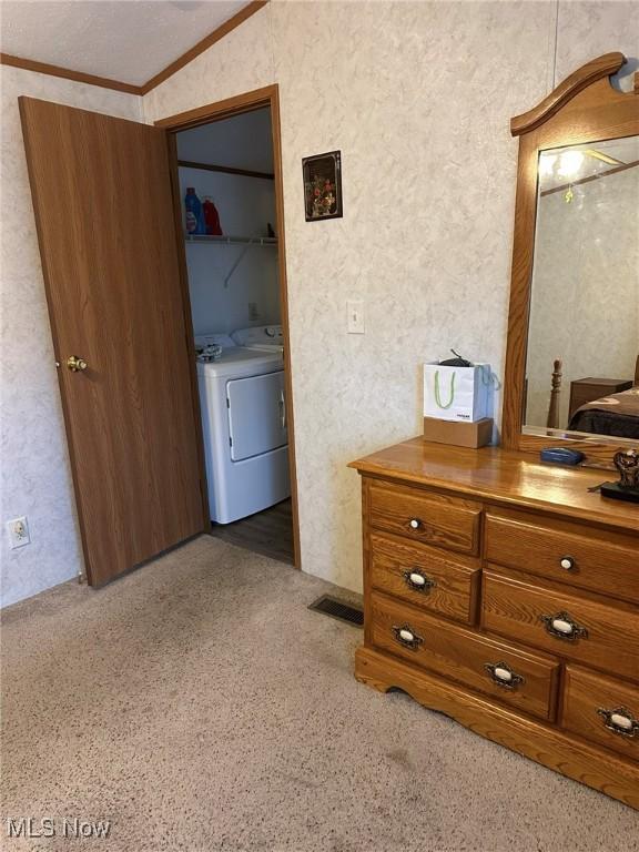 bedroom featuring washer / clothes dryer, vaulted ceiling, and ornamental molding