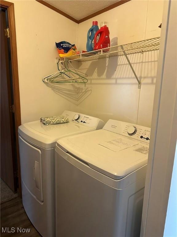 clothes washing area featuring ornamental molding, dark hardwood / wood-style flooring, and separate washer and dryer