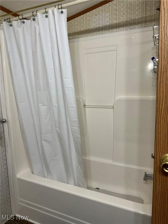 bathroom with shower / tub combo with curtain