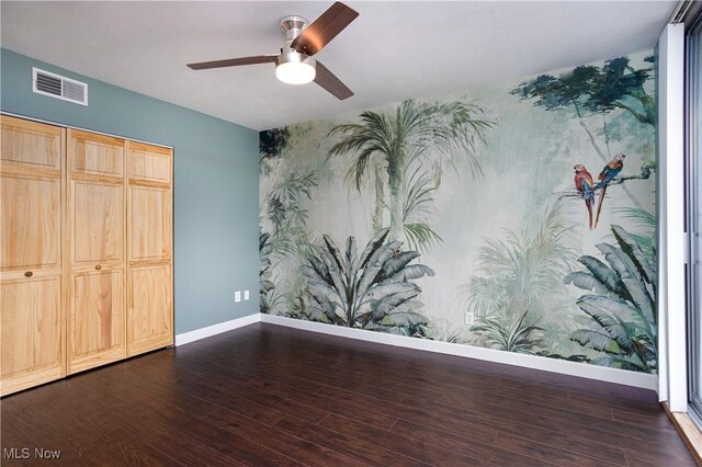 unfurnished bedroom featuring an accent wall, wallpapered walls, and baseboards