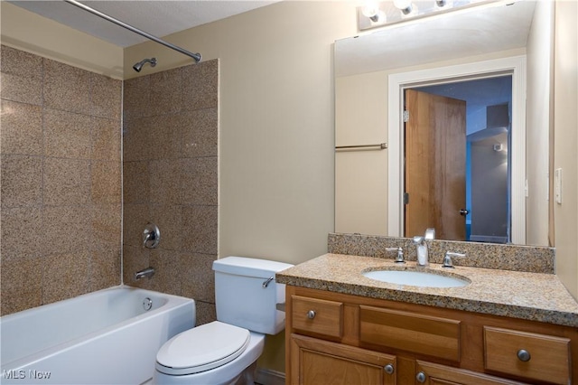 full bathroom featuring vanity, tiled shower / bath, and toilet