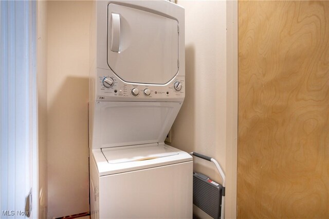 laundry area featuring stacked washer / drying machine and laundry area