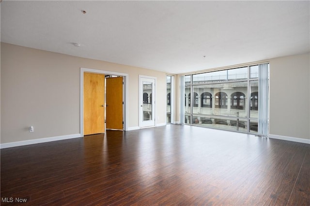 unfurnished living room with dark hardwood / wood-style flooring and floor to ceiling windows