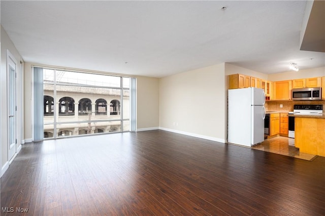 unfurnished living room featuring expansive windows and light wood-type flooring