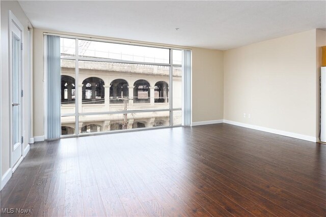 empty room with baseboards and wood finished floors