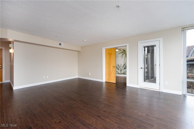 unfurnished room featuring dark wood-style flooring and baseboards