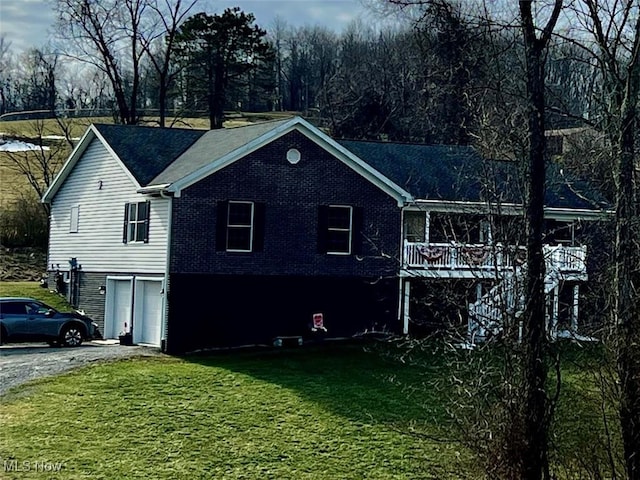 view of side of property featuring a garage, a yard, and a deck